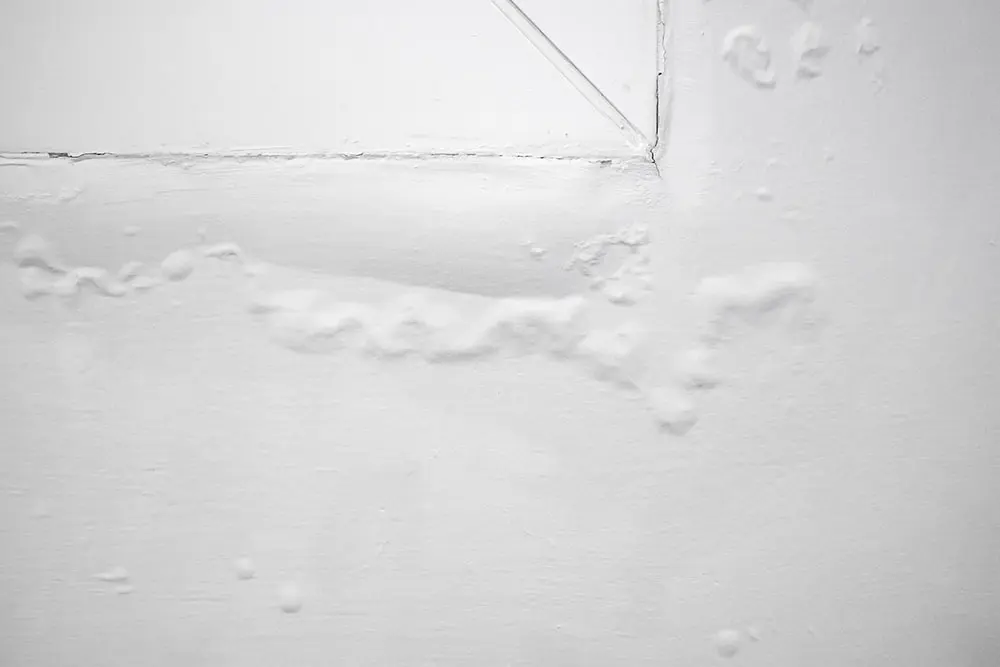 Peinture cloquée et gonflée sur un mur en raison d’une infiltration d’eau