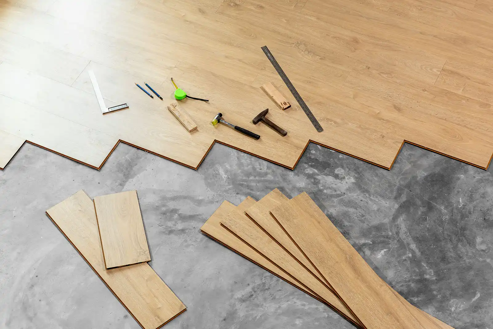 Pose d’un parquet flottant en stratifié avec outils sur dalle béton