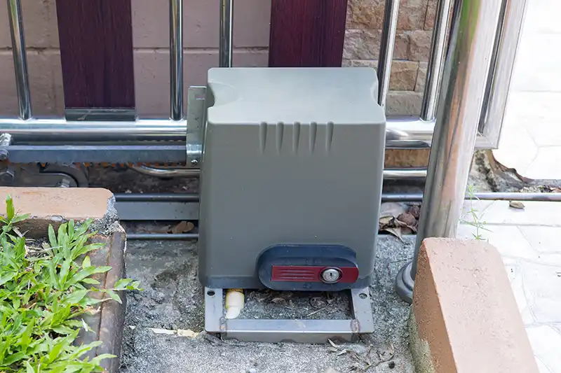 Serrure de déverrouillage d’un moteur de portail coulissant électrique, indiquée en rouge, permettant l’ouverture manuelle en cas de coupure de courant