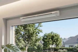 Gros plan d'un système d'aération de fenêtre sans percer installé sur un cadre de fenêtre blanc avec vue sur un jardin.