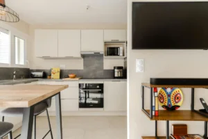 Cuisine ouverte avec meubles intégrés, espace repas et rangements optimisés, illustrant la différence entre aménagement et agencement.