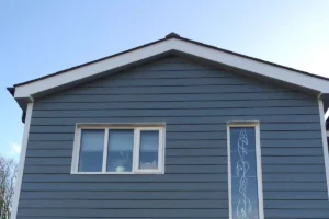 Gouttière PVC blanche installée sur la façade d’une maison avec descentes d’eau pluviale