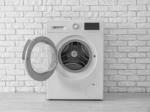 Photo d'une machine à laver hublot grand ouvert, montrant le tambour en inox vide, un élément clé pour diagnostiquer les bruits et vibrations excessives à l'essorage.