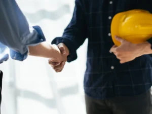 Poignée de main avec un artisan du bâtiment après la validation du devis et le versement de l'acompte pour les travaux
