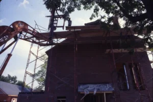 Façade de maison en briques en cours de rénovation avec échafaudage métallique rouge